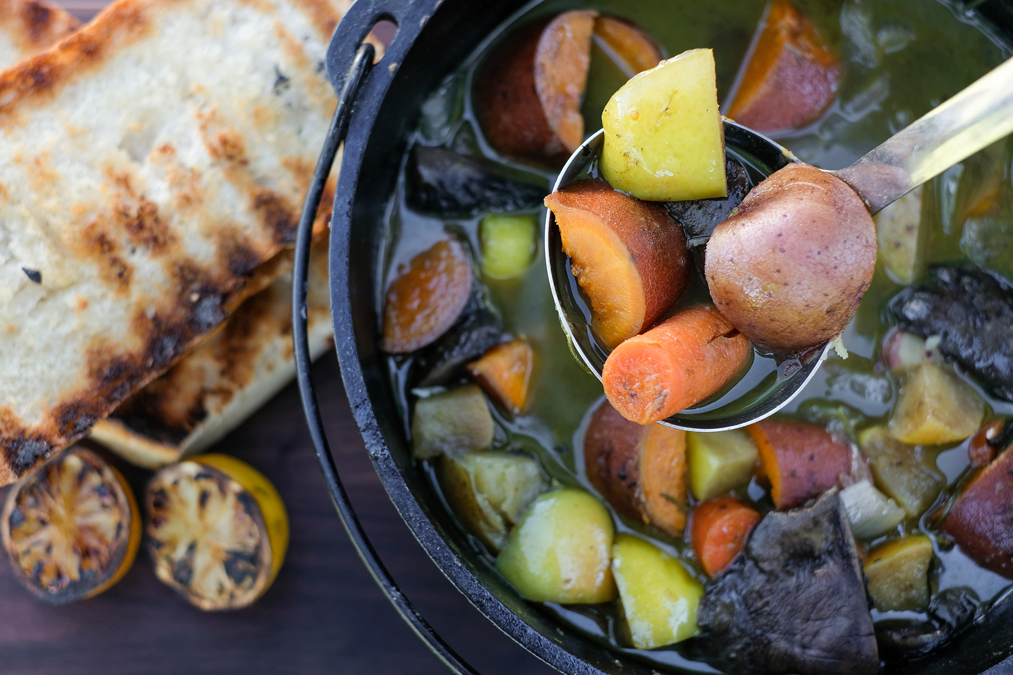Pioneer Stew with root vegetables in a cast iron pot over a campfire